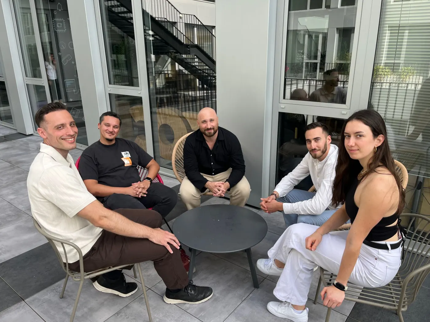 The ForgeTheWeb team seated around a coffee table on a terrace: from left to right, Vincent, Xavier, Jérôme, Mickaël and Lilas